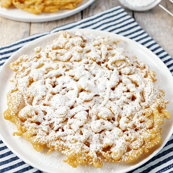 a white plate topped with powdered sugar on top of a blue and white table cloth