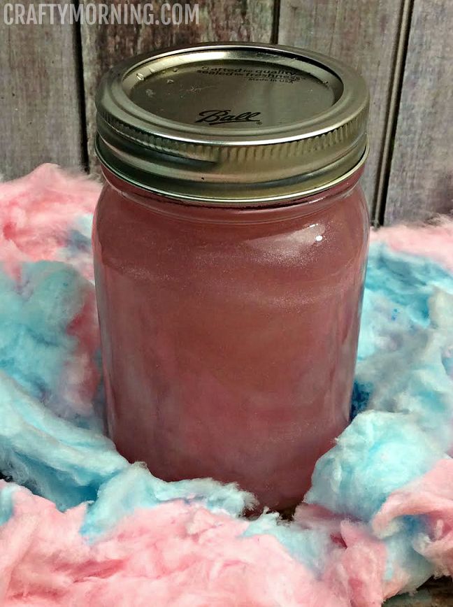 a mason jar sitting on top of a pile of pink and blue yarn