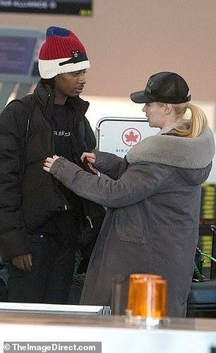 two people standing next to each other at an airport