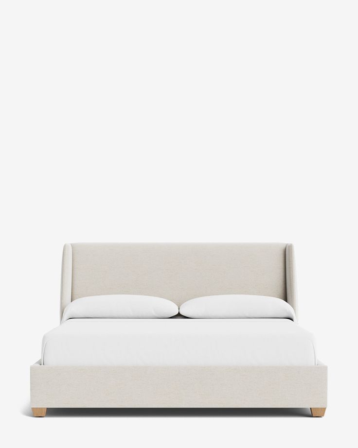 a bed with white sheets and pillows on it's headboard, in front of a gray wall