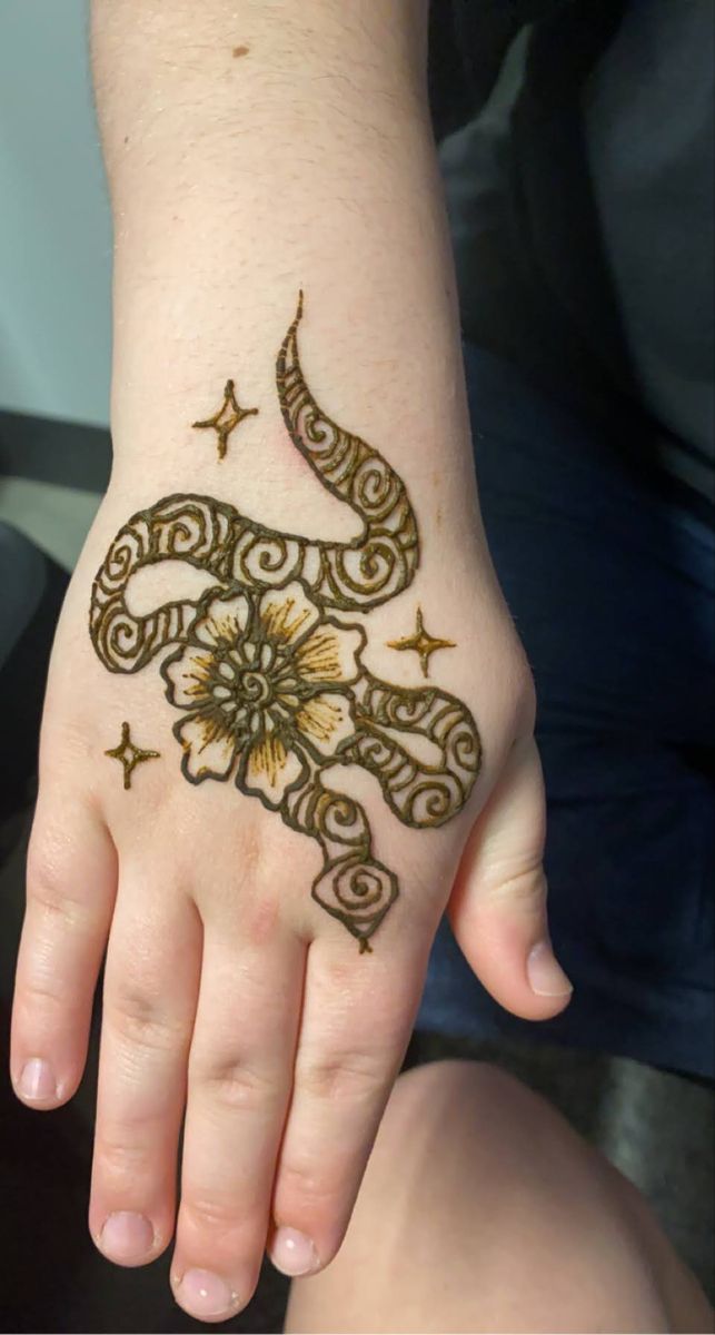 a woman's hand with a henna tattoo on it