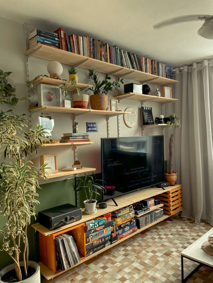 a living room filled with furniture and a flat screen tv sitting on top of a wooden shelf