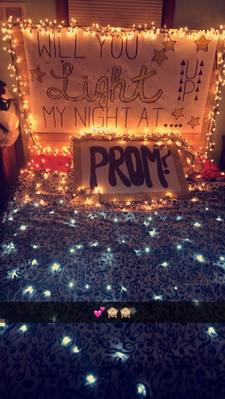 a bed covered in christmas lights with a sign that says prom