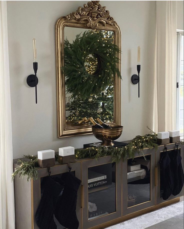 a christmas mantle with stockings and candles on it in front of a mirror that is hung above the fireplace