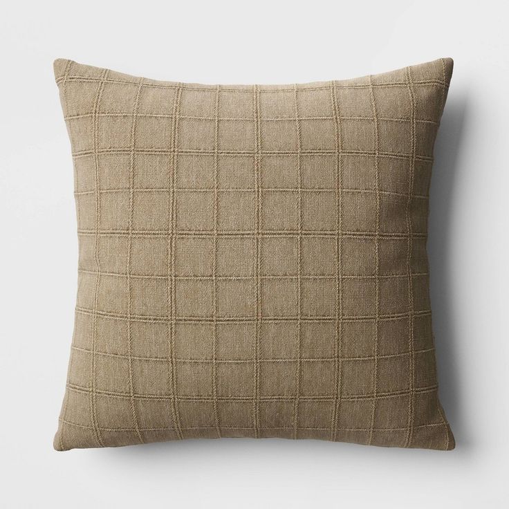 a beige pillow with a checkered pattern on it