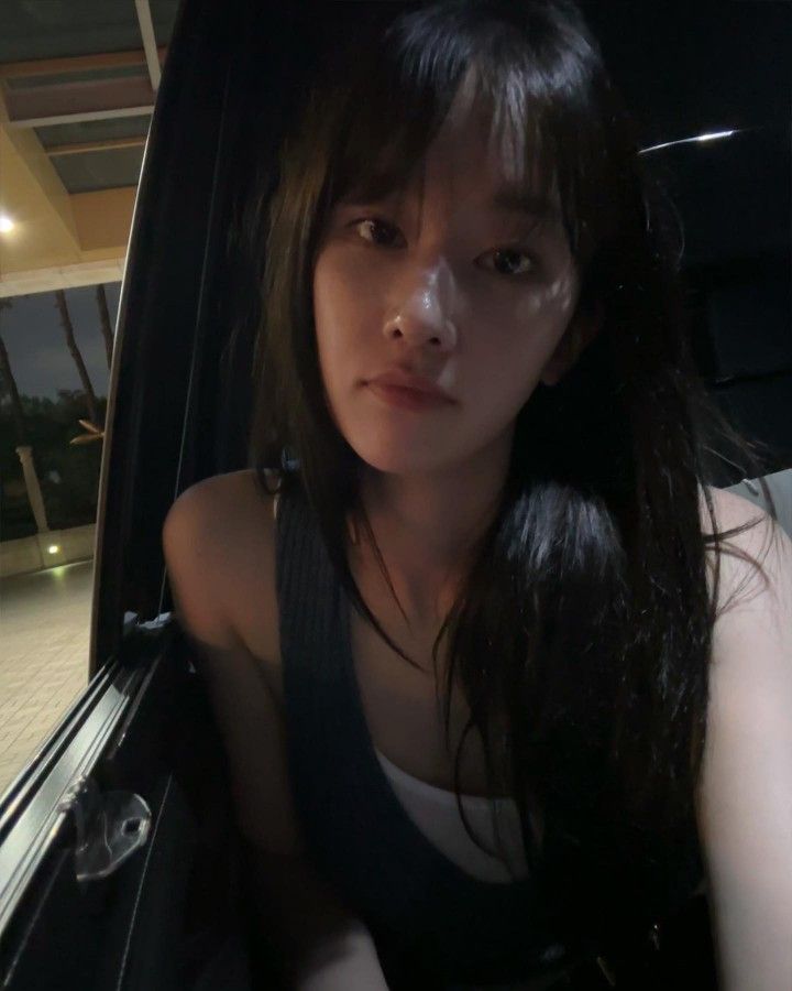 a young woman sitting in the back seat of a car looking at the camera with an intense look on her face