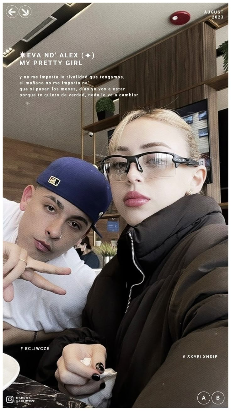 a man and woman posing for a photo in front of a computer screen with their fingers up