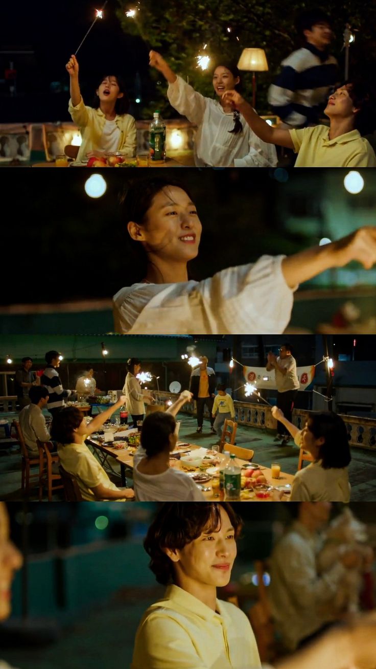 people sitting around a table with lights in the air and one person holding up his hand