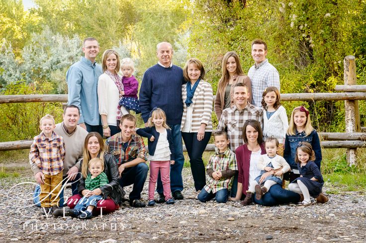 a large group of people standing next to each other in front of a wooden fence