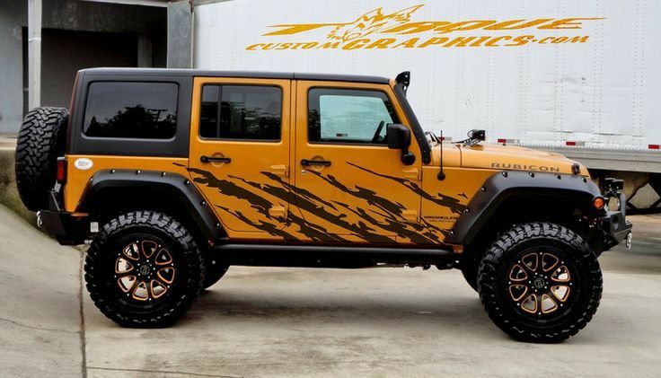 a yellow and black jeep parked in front of a truck with the words custom graphics on it