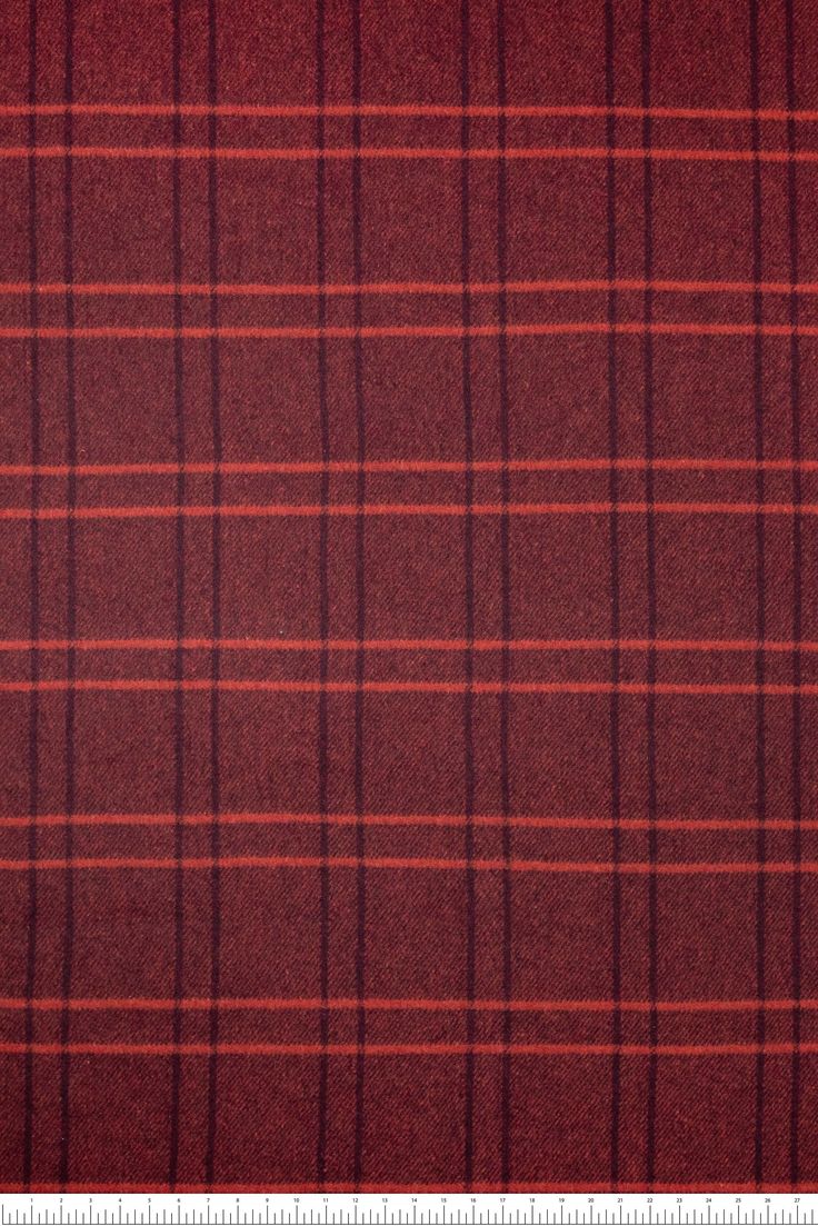 a red and black plaid fabric with a ruler in front of the bottom right corner