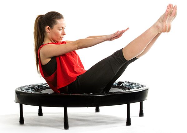 a woman sitting on top of a trampoline with her legs spread wide open