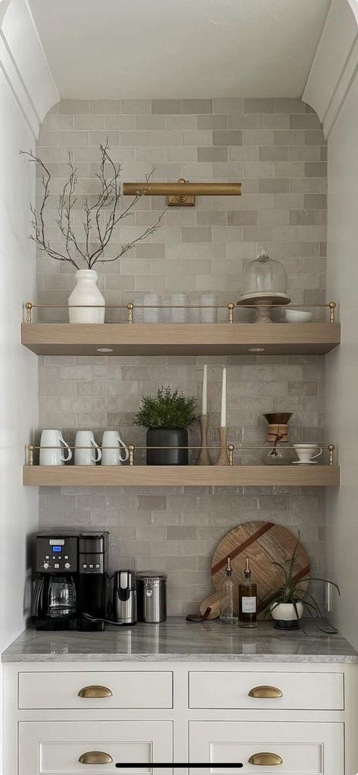 a kitchen with white cabinets and shelves filled with dishes