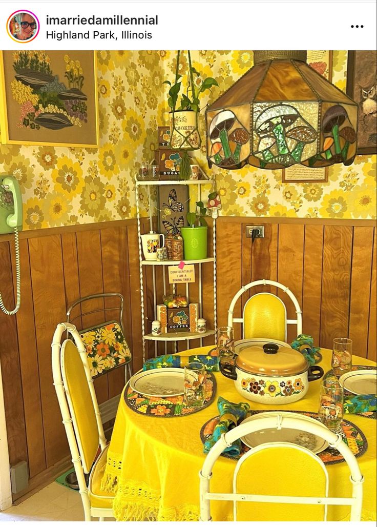 a dining room with yellow table cloths and plates on top of the table in front of a wooden paneled wall