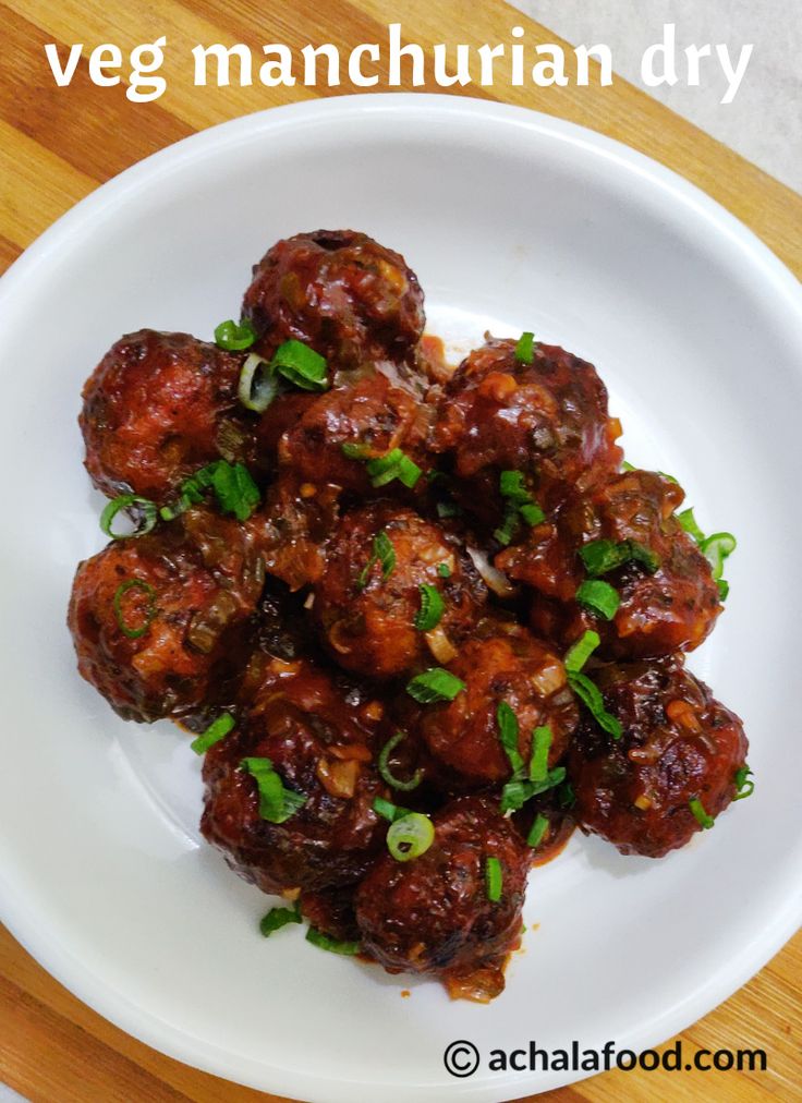 a white plate topped with meatballs covered in sauce