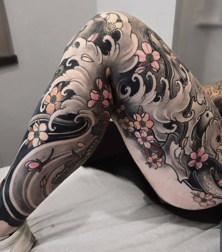 a woman laying on top of a bed covered in tattoos