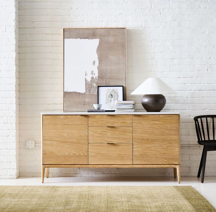 a white brick wall in a room with a wooden dresser and chair next to it