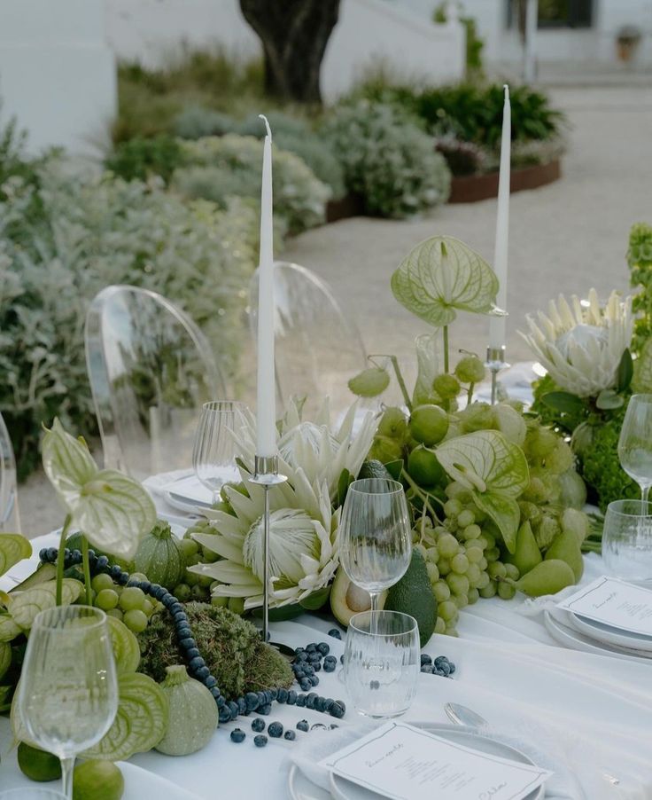 the table is set with wine glasses, plates and silverware