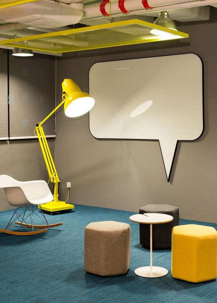 an office with chairs, tables and a big white speech bubble