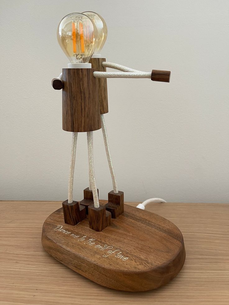 a wooden table with a lamp on top of it and wires attached to the light bulb