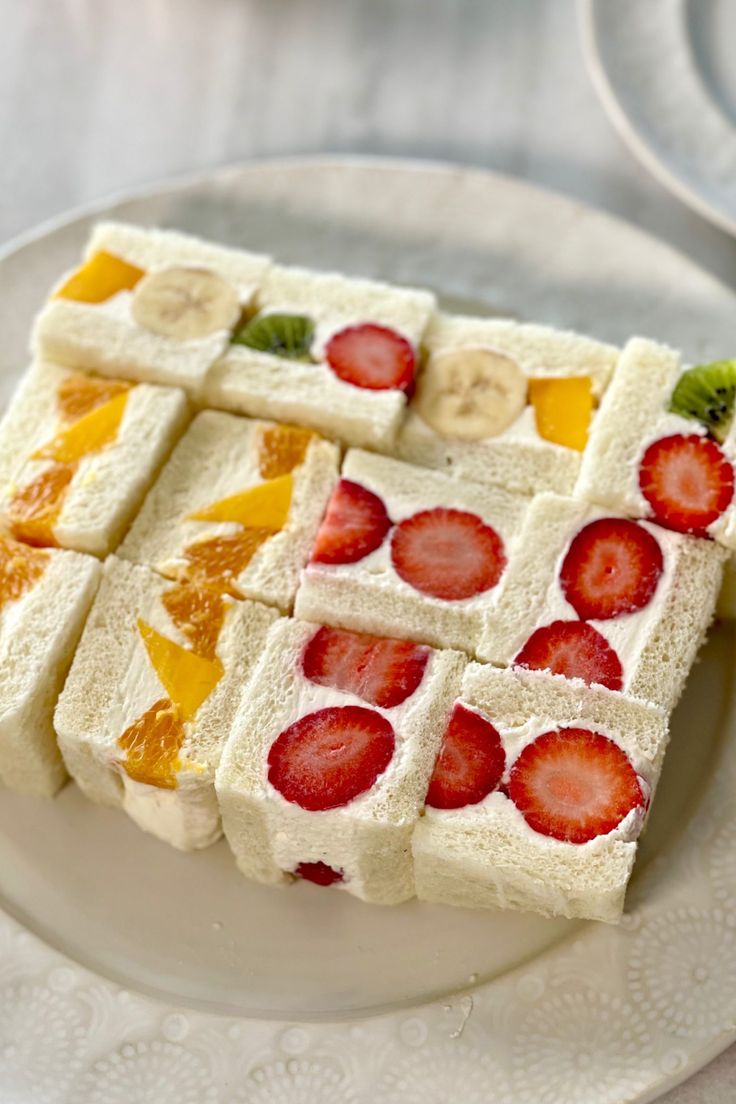 there is a white plate with fruit squares on it