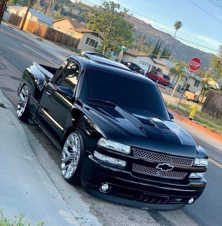 a black truck is parked on the side of the road