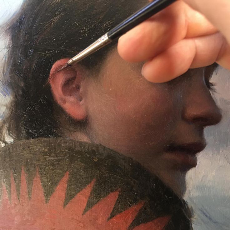 a woman is drawing on her face with a marker