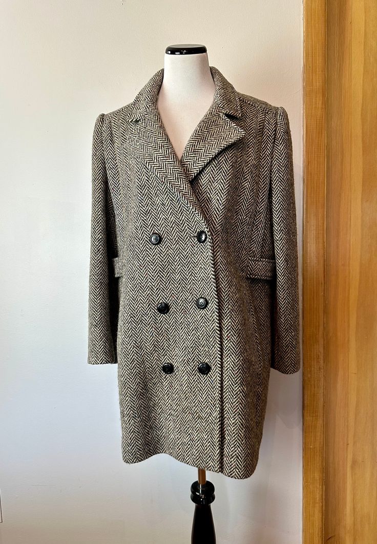 "This is a very good classic style. Very timeless Women's wool overcoat. Plus size.. grey and off white weave with subtle flecks of blue , red and other sprinkled in. Although those flecks don't really read so much but upon very close up. Mostly it looks like a warm grayish- natural off white.  It's not actually double breasted but it has that look similar to a peacoat style. (But it's not of course) The only flaws or some older water like spots on the inner purple satin lining. The wool coat it Peacoat Style, Tweed Overcoat, 90s Era, Wool Overcoat, White Tweed, Purple Satin, Vintage Wool, Wool Coat, Herringbone