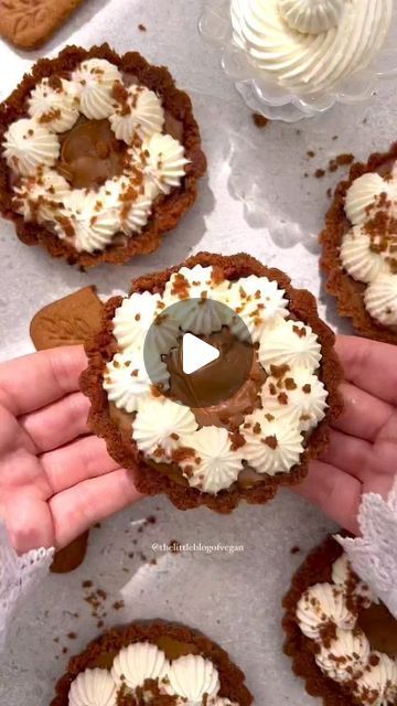 someone is holding some desserts with icing and chocolate on them in their hands