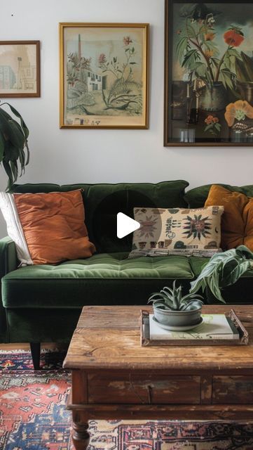 a living room with green couches and paintings on the wall above them, along with a coffee table