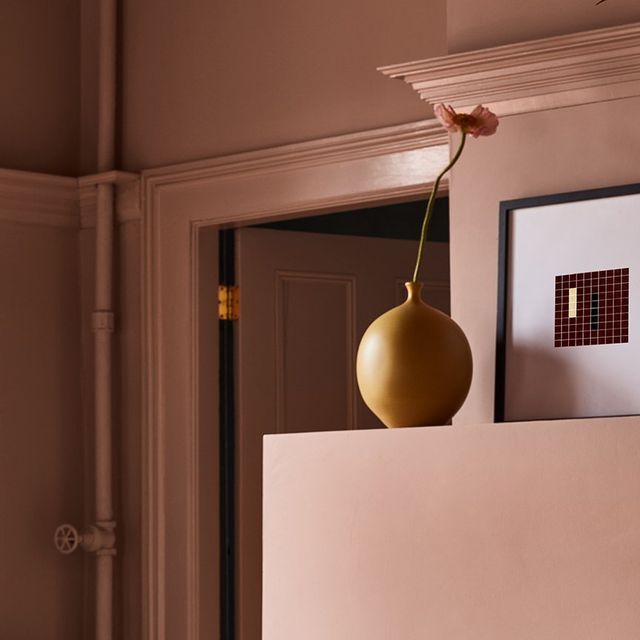 a yellow vase sitting on top of a white shelf next to a framed photo and flower