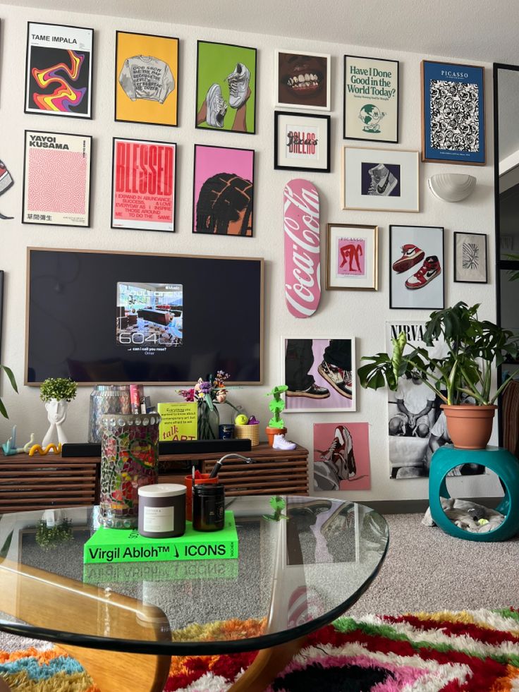 a living room filled with furniture and lots of framed pictures on the wall behind a glass coffee table