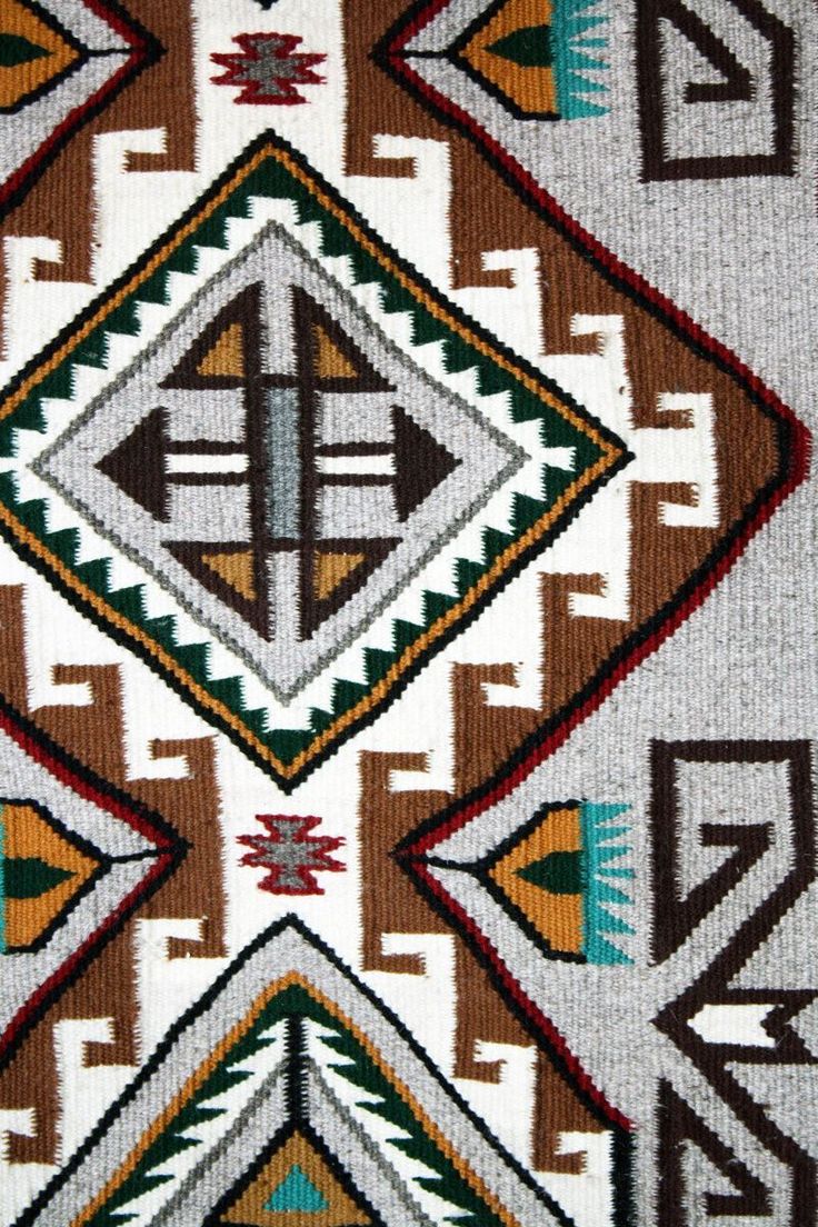 an old navajo rug with geometric designs on the side and brown, white, green, orange