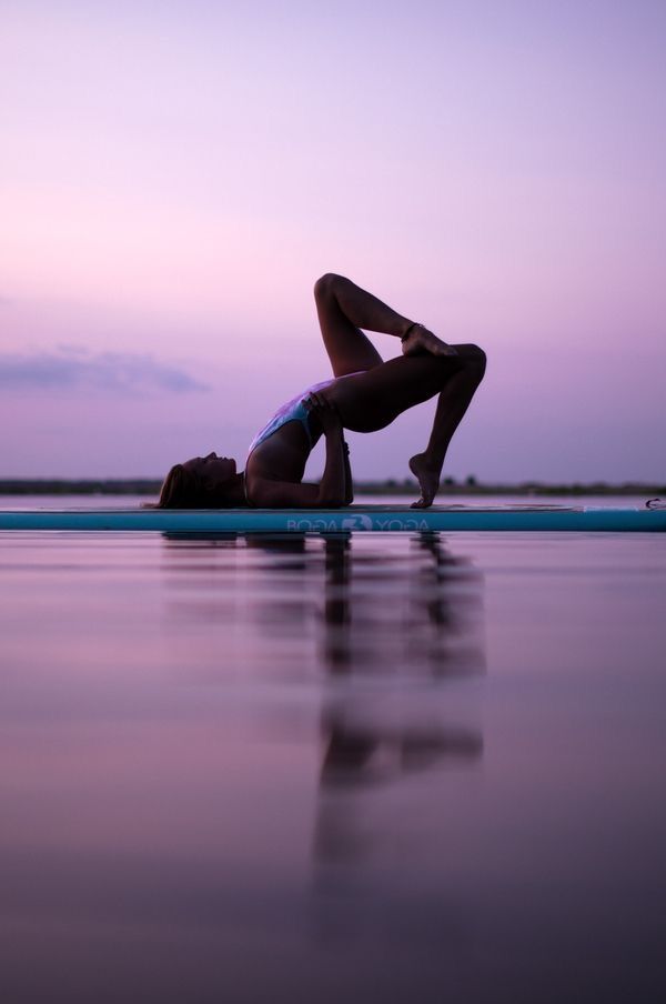 a person laying on top of a surfboard in the water at sunset or dawn