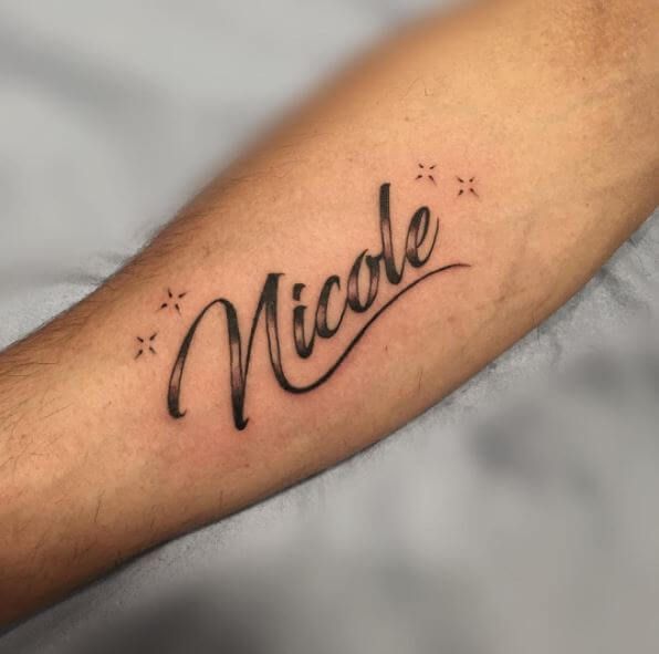 a man's arm with the word nicole written in cursive writing on it