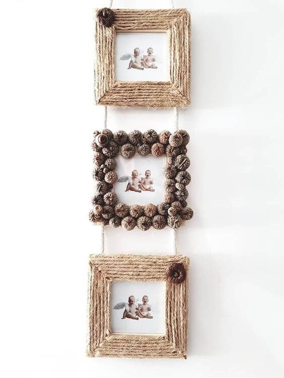 two framed pictures hanging on the wall with pine cones and twine balls attached to them