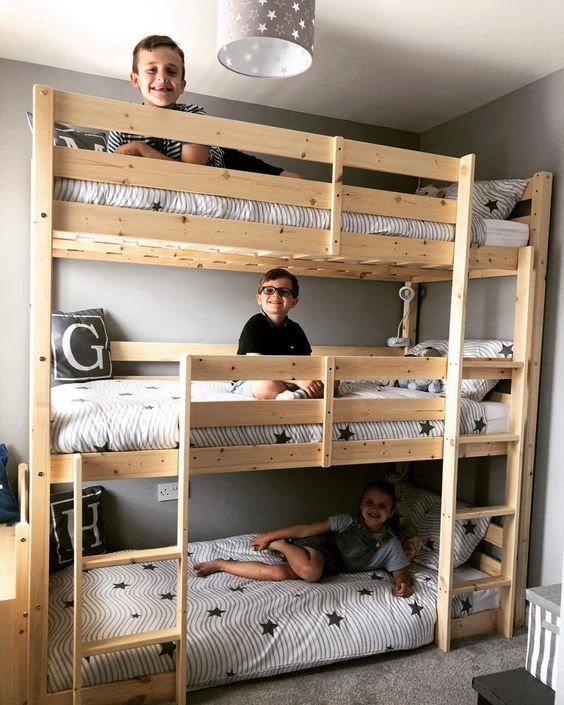 two children sitting on bunk beds in a room