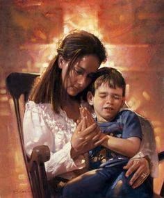 a woman sitting next to a boy in a chair with his hands folded over him