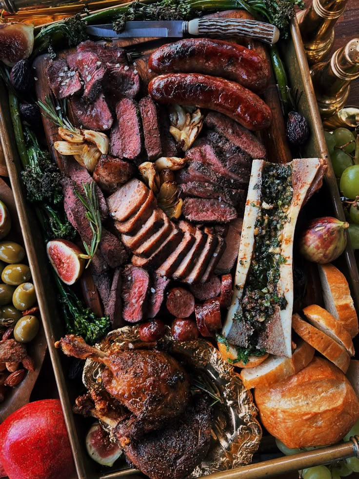 an assortment of meats and vegetables in a wooden box with gold trimmings