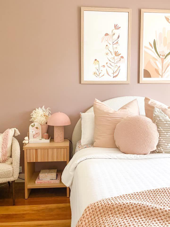 a bed room with a neatly made bed and two pictures on the wall above it