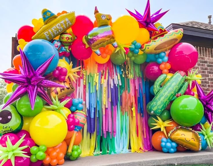 balloons, streamers and other decorations are on display in front of a brick building