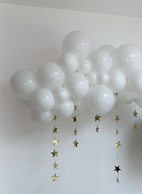 white balloons with gold stars hanging from the ceiling