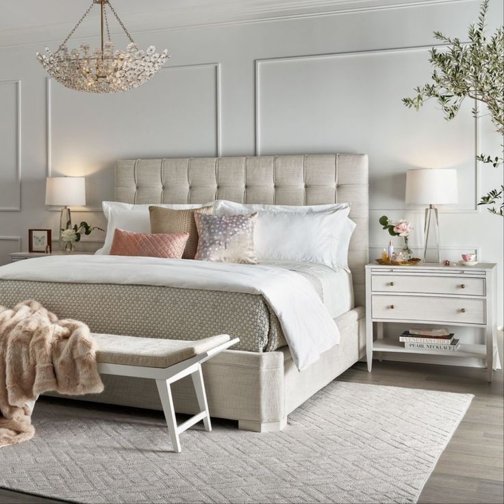 a bedroom with white walls and furniture in the corner, including a bed that is upholstered