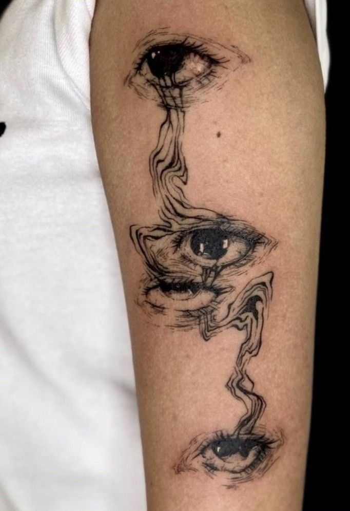 a person with a black and white tattoo on their arm that has an eye in the middle