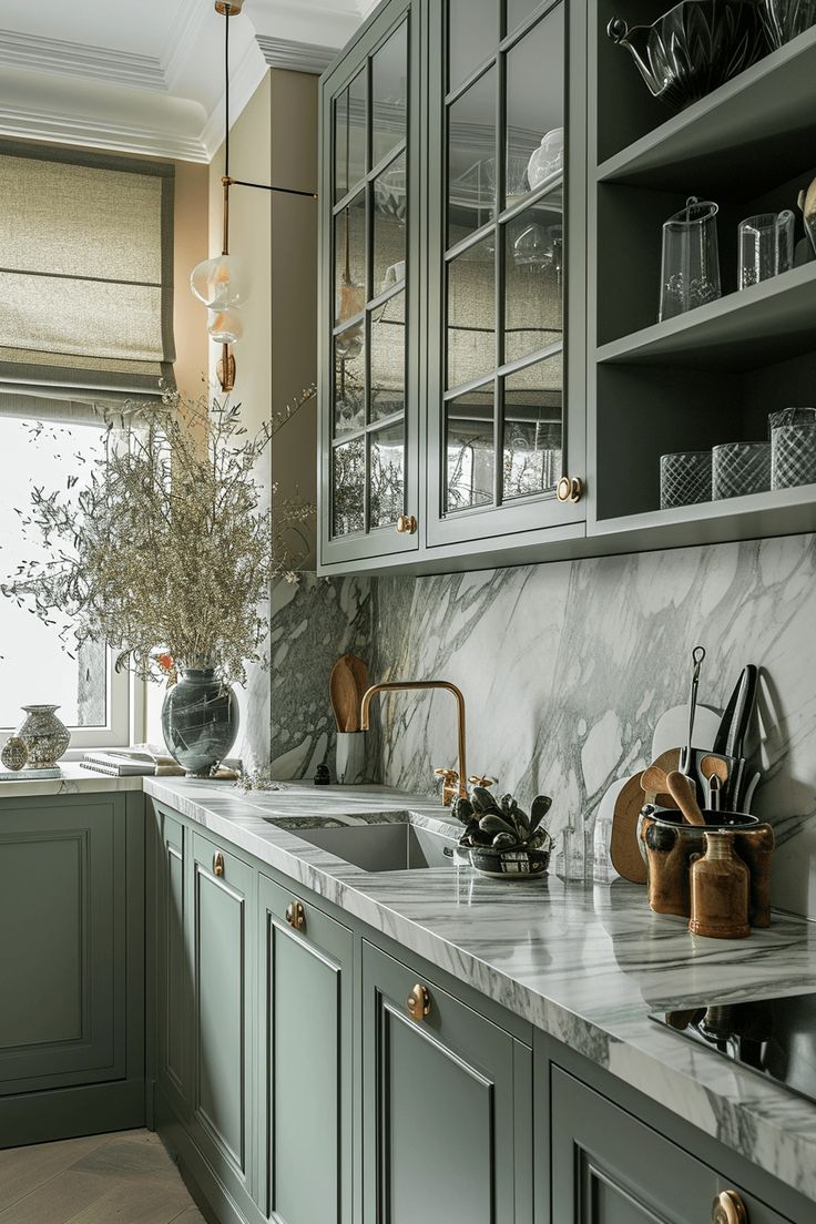 a kitchen with green cabinets and marble counter tops, along with an open window to the outside