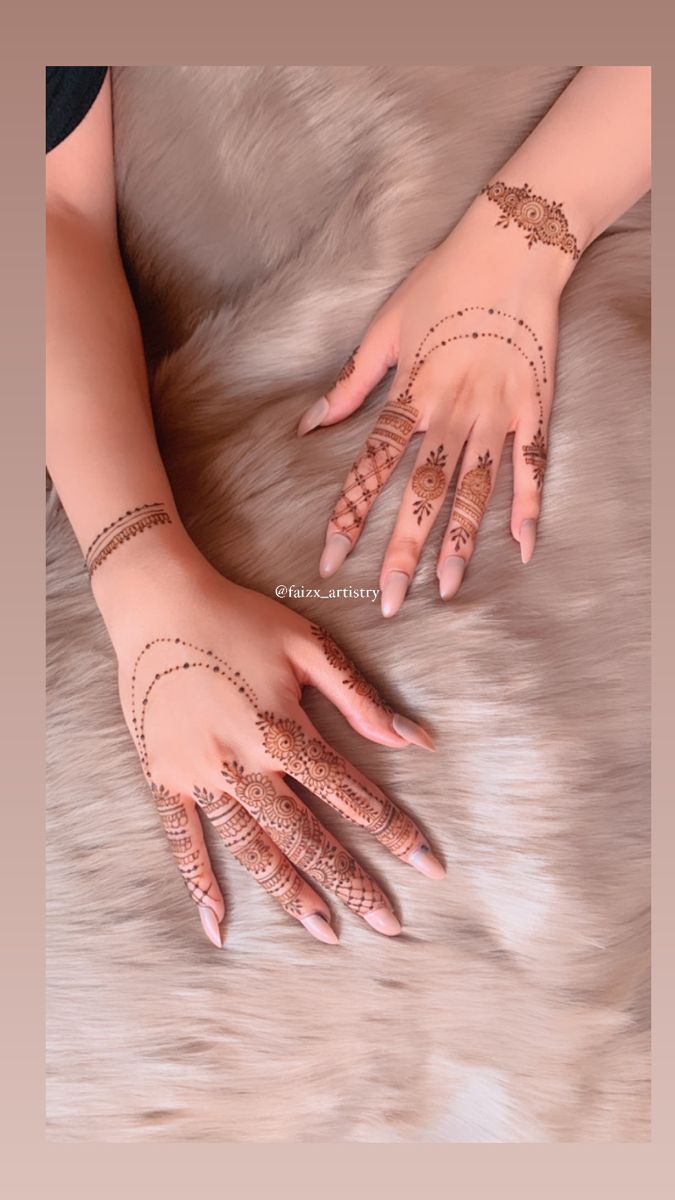 two hands with henna tattoos on them