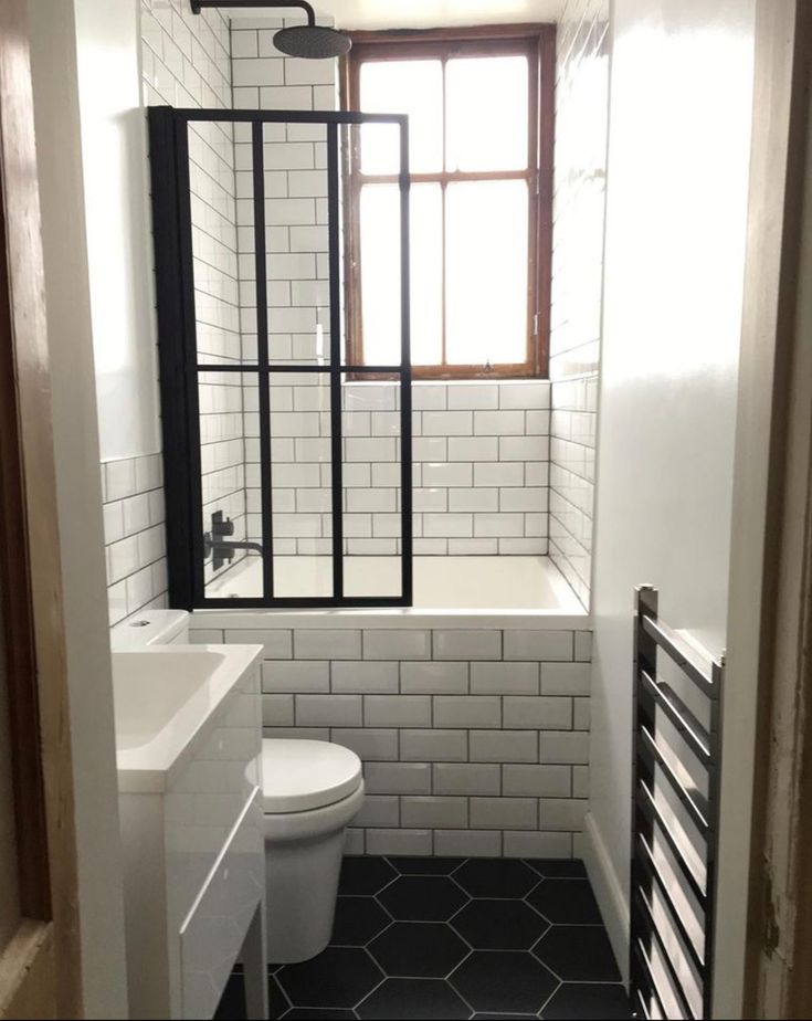 a white toilet sitting next to a window in a bathroom