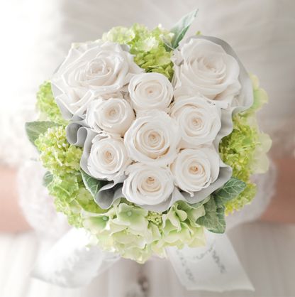 a bride holding a bouquet of white flowers