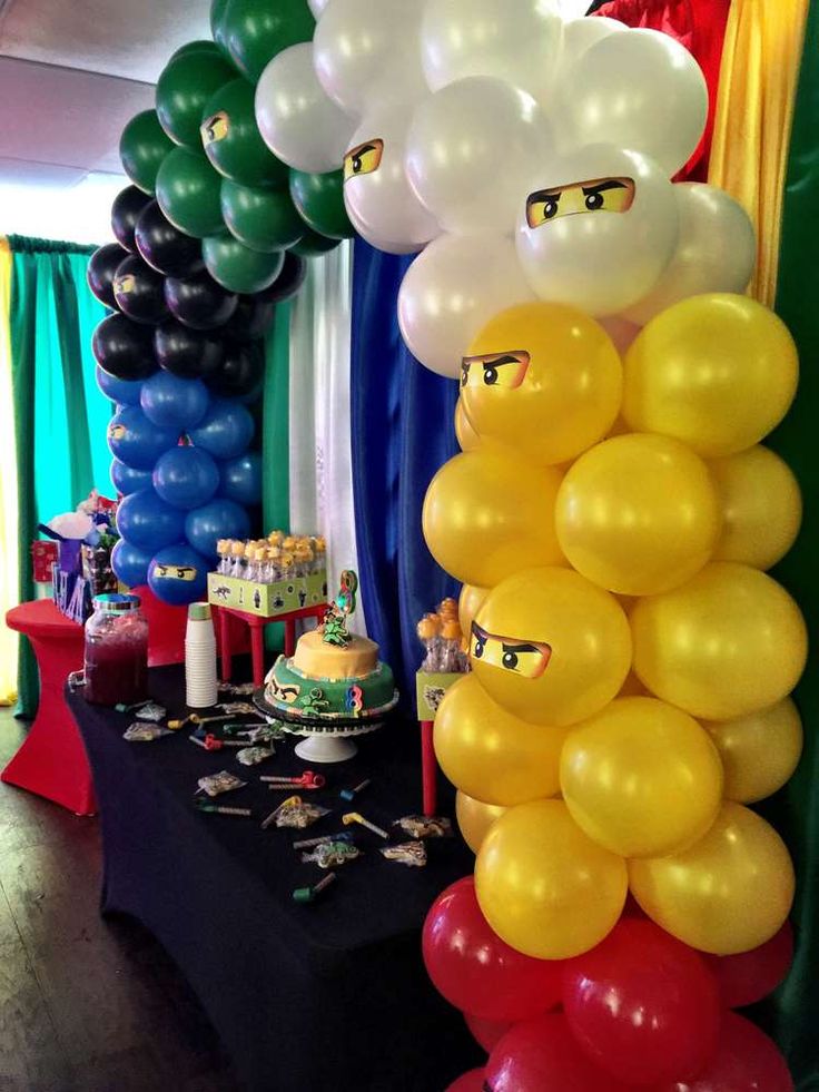 a table topped with lots of balloons and cake