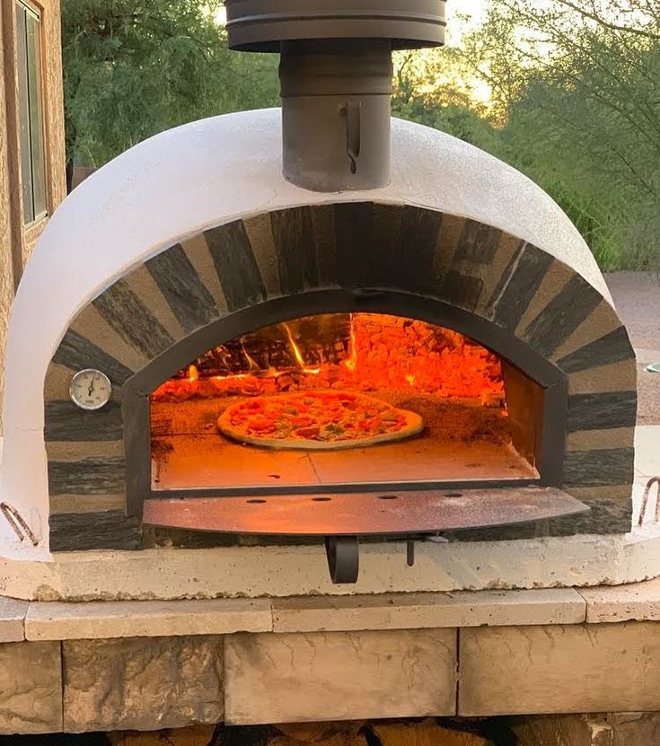 an outdoor pizza oven is shown with the door open to show it's cooking area